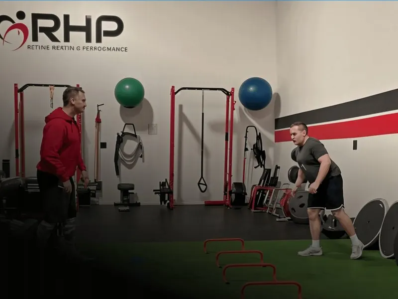 Jeremy Dillon coaches a client through guided training on the turf at Rewire Health & Performance