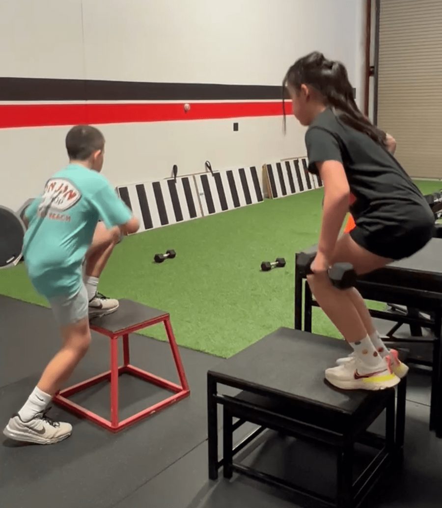 Youth athletes perform weighted step-ups on plyo boxes during athletic development training at RHP